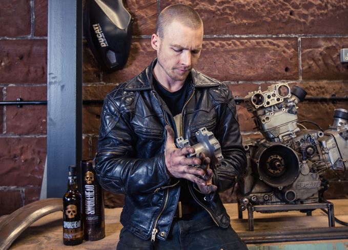 Tyler Lunceford with Smokehead whisky in motorbike workshop