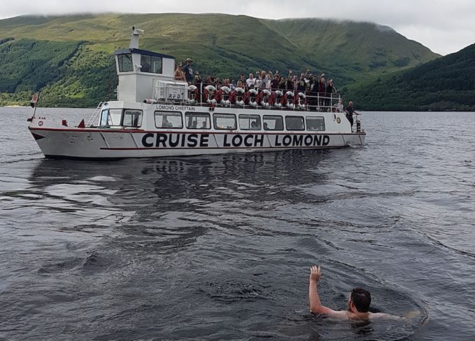 Swimmer and boat in Loch Lomond