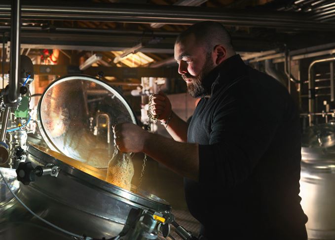 Lakes distillery checks yeast fermenting wash in a washback