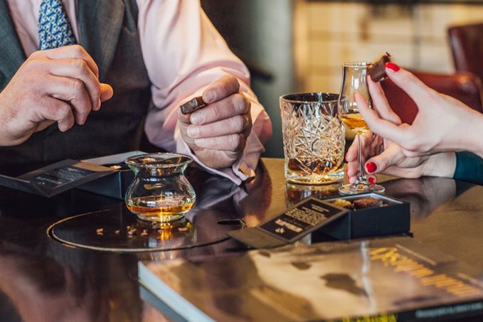 Man and woman enjoying whisky and chocolate