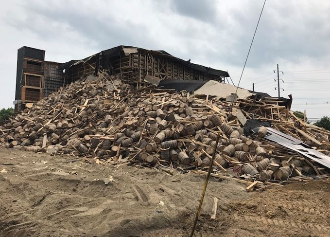 Debris and piled barrels at the collapsed OZ Tyler warehouse