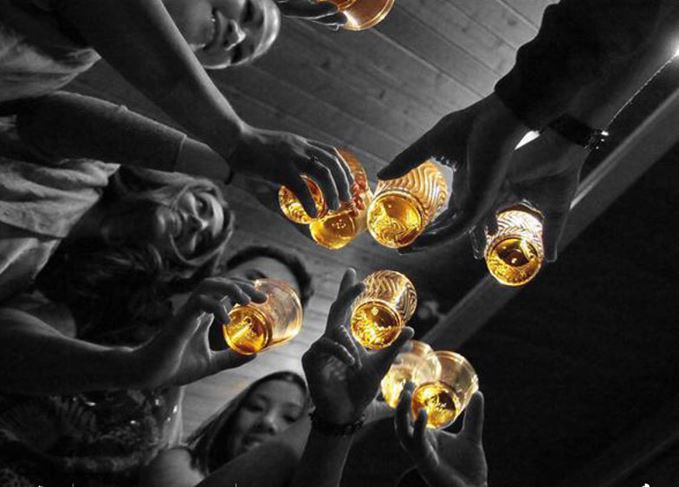 Friends toasting with whisky glasses